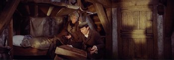 Movie still from “The Wonderful World of the Brothers Grimm” (1962), directed by Henry Levin – A man and a woman sitting on a bench; Medium shot, Overhead angle