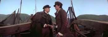 Movie still from “The Wonderful World of the Brothers Grimm” (1962), directed by Henry Levin – Two men in suits and hats talking on a boat; Medium shot, Low angle