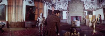 Movie still from “The Wonderful World of the Brothers Grimm” (1962), directed by Henry Levin – A man standing next to a suit of armor; Wide shot, Over the shoulder angle