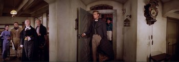 Movie still from “The Wonderful World of the Brothers Grimm” (1962), directed by Henry Levin – A man standing in front of an open door; Medium shot, Over the shoulder angle