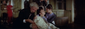 Movie still from “The Wonderful World of the Brothers Grimm” (1962), directed by Henry Levin – A group of people standing next to each other in a room; Medium shot, High angle