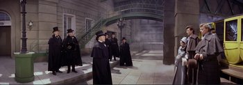Movie still from “The Wonderful World of the Brothers Grimm” (1962), directed by Henry Levin – A group of people dressed up in black robes; Wide shot, High angle