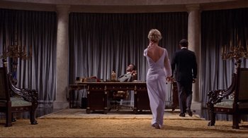 Movie still from “The Wrecking Crew” (1968), directed by Phil Karlson – A woman standing in front of two men in front of a desk; Wide shot, Low angle