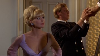 Movie still from “The Wrecking Crew” (1968), directed by Phil Karlson – A man and a woman standing next to each other in a room; Medium shot, Low angle