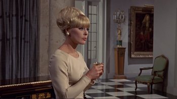 Movie still from “The Wrecking Crew” (1968), directed by Phil Karlson – A woman with blonde hair holding a cup in her hand; Medium shot, Over the shoulder angle
