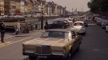 Movie still from “The Wrecking Crew” (1968), directed by Phil Karlson – Cars are lined up on the side of the road; Wide shot, High angle