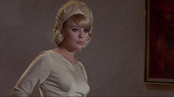 Movie still from “The Wrecking Crew” (1968), directed by Phil Karlson – A woman in a white dress and a white hat; Close Up shot, Low angle