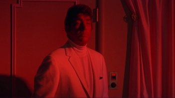 Movie still from “The Wrecking Crew” (1968), directed by Phil Karlson – A man wearing a white suit standing in a room; Medium shot, Low angle