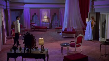 Movie still from “The Wrecking Crew” (1968), directed by Phil Karlson – A living room filled with furniture next to a large window; Extreme Wide shot, High angle