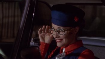 Movie still from “The Wrecking Crew” (1968), directed by Phil Karlson – A woman wearing a hat and glasses sitting in a car; Close Up shot, Over the shoulder angle