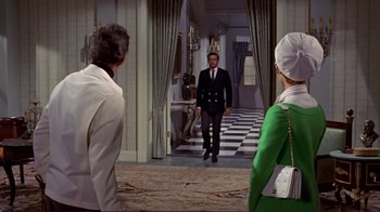 Movie still from “The Wrecking Crew” (1968), directed by Phil Karlson – A man and two women are standing in front of a doorway; Wide shot, Over the shoulder angle