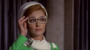 Movie still from “The Wrecking Crew” (1968), directed by Phil Karlson – A woman wearing glasses and a green outfit; Close Up shot, Low angle