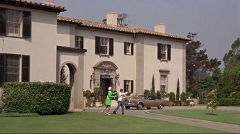 Movie still from “The Wrecking Crew” (1968), directed by Phil Karlson – A couple of people that are in front of a house; Extreme Wide shot, Low angle