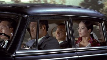 Movie still from “The Wrecking Crew” (1968), directed by Phil Karlson – A group of people sitting in the back of a car; Medium shot, Low angle