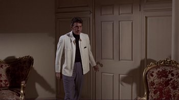 Movie still from “The Wrecking Crew” (1968), directed by Phil Karlson – A man in a white jacket standing in front of a white door; Medium shot, Over the shoulder angle