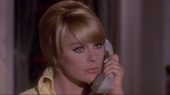 Movie still from “The Wrecking Crew” (1968), directed by Phil Karlson – A woman talking on a phone while wearing a yellow shirt; Close Up shot, Low angle