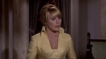 Movie still from “The Wrecking Crew” (1968), directed by Phil Karlson – A woman in a yellow jacket is looking at the camera; Close Up shot, Over the shoulder angle
