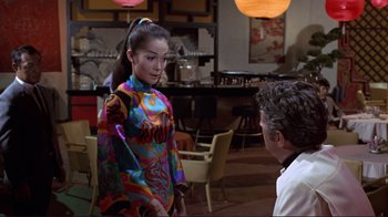 Movie still from “The Wrecking Crew” (1968), directed by Phil Karlson – A man and a woman in colorful outfits in a restaurant; Medium shot, Over the shoulder angle