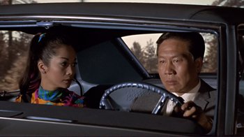 Movie still from “The Wrecking Crew” (1968), directed by Phil Karlson – A man and a woman sitting in the drivers seat of a car; Medium shot, Low angle
