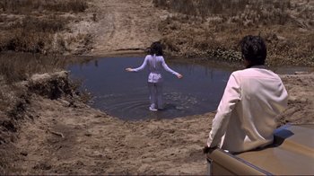 Movie still from “The Wrecking Crew” (1968), directed by Phil Karlson – A woman standing in a shallow pool of water near a man; Wide shot, High angle