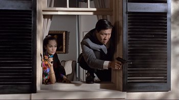 Movie still from “The Wrecking Crew” (1968), directed by Phil Karlson – A man and a woman are holding a gun in a room; Medium shot, Low angle
