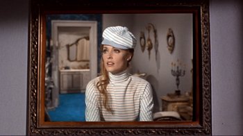 Movie still from “The Wrecking Crew” (1968), directed by Phil Karlson – A woman wearing a hat in front of a mirror in a room; Medium shot, Over the shoulder angle