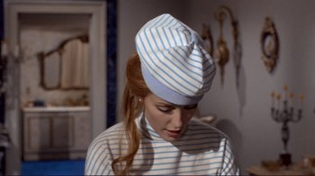 Movie still from “The Wrecking Crew” (1968), directed by Phil Karlson – A woman in a striped shirt wearing a blue and white hat; Medium shot, High angle