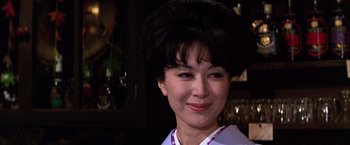 Movie still from “The Yakuza” (1974), directed by Sydney Pollack – A person smiling for the camera; Close Up shot, Low angle