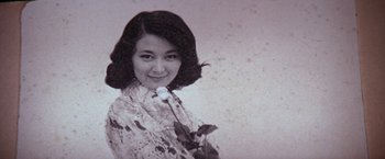 Movie still from “The Yakuza” (1974), directed by Sydney Pollack – An old black and white photo of a woman holding a rose; Extreme Close Up shot, Low angle