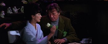 Movie still from “The Yakuza” (1974), directed by Sydney Pollack – A man and a woman sitting at a dinner table; Medium shot, Over the shoulder angle