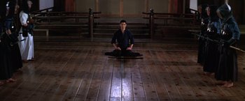 Movie still from “The Yakuza” (1974), directed by Sydney Pollack – A man sitting on the ground in a dark room; Wide shot, High angle