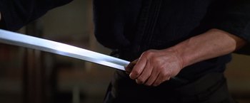 Movie still from “The Yakuza” (1974), directed by Sydney Pollack – A person holding a sword in their hand; Extreme Close Up shot, Low angle