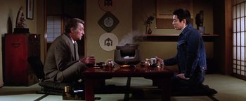 Movie still from “The Yakuza” (1974), directed by Sydney Pollack – Two men sitting at a table in front of a tea pot; Medium shot, High angle
