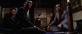Movie still from “The Yakuza” (1974), directed by Sydney Pollack – A group of men sitting on the ground in a room; Medium shot, Low angle