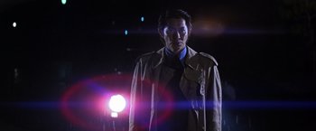Movie still from “The Yakuza” (1974), directed by Sydney Pollack – A man wearing a trench coat standing in front of a street light at night; Medium shot, Low angle
