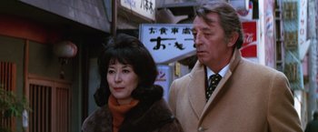 Movie still from “The Yakuza” (1974), directed by Sydney Pollack – An older man standing next to an older woman; Close Up shot, Low angle