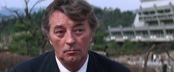 Movie still from “The Yakuza” (1974), directed by Sydney Pollack – A person wearing a suit and tie; Close Up shot, Low angle