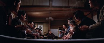 Movie still from “The Yakuza” (1974), directed by Sydney Pollack – A group of people sitting around a table; Wide shot, Low angle