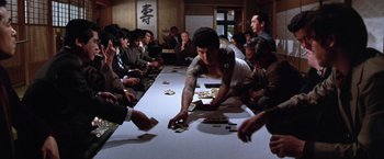 Movie still from “The Yakuza” (1974), directed by Sydney Pollack – A group of people sitting around a table with cards; Medium shot, Over the shoulder angle