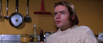 Movie still from “The Yakuza” (1974), directed by Sydney Pollack – A man with long hair wearing a white sweater; Close Up shot, Low angle