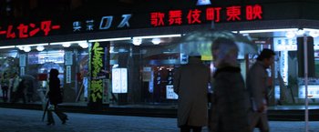 Movie still from “The Yakuza” (1974), directed by Sydney Pollack – Two people walking on the sidewalk in front of a store; Wide shot, Low angle