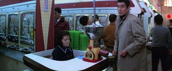 Movie still from “The Yakuza” (1974), directed by Sydney Pollack – A woman sitting in front of a coffee grinder; Medium shot, Over the shoulder angle