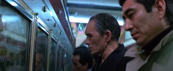 Movie still from “The Yakuza” (1974), directed by Sydney Pollack – A person on a subway train; Close Up shot, Low angle