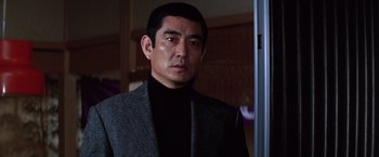 Movie still from “The Yakuza” (1974), directed by Sydney Pollack – A person wearing a suit; Close Up shot, Low angle