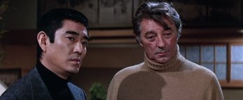 Movie still from “The Yakuza” (1974), directed by Sydney Pollack – Two men standing next to each other in a room; Close Up shot, Over the shoulder angle