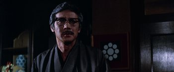 Movie still from “The Yakuza” (1974), directed by Sydney Pollack – An older man wearing glasses and a robe; Close Up shot, Low angle