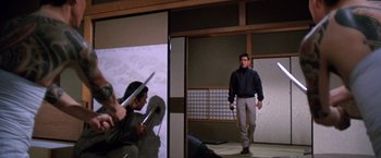Movie still from “The Yakuza” (1974), directed by Sydney Pollack – A man holding a sword in front of another man with a sword; Wide shot, Low angle