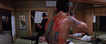 Movie still from “The Yakuza” (1974), directed by Sydney Pollack – A group of people that are standing up in a room; Medium shot, High angle