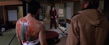 Movie still from “The Yakuza” (1974), directed by Sydney Pollack – A man standing in a room next to another man; Medium shot, Over the shoulder angle