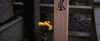 Movie still from “The Yakuza” (1974), directed by Sydney Pollack – A vase of yellow flowers in front of a sign; Extreme Close Up shot, Low angle